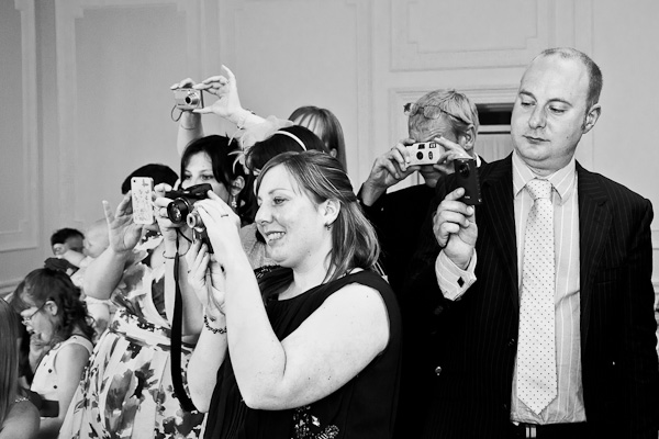 wedding guests using cameras taking photos at wedding