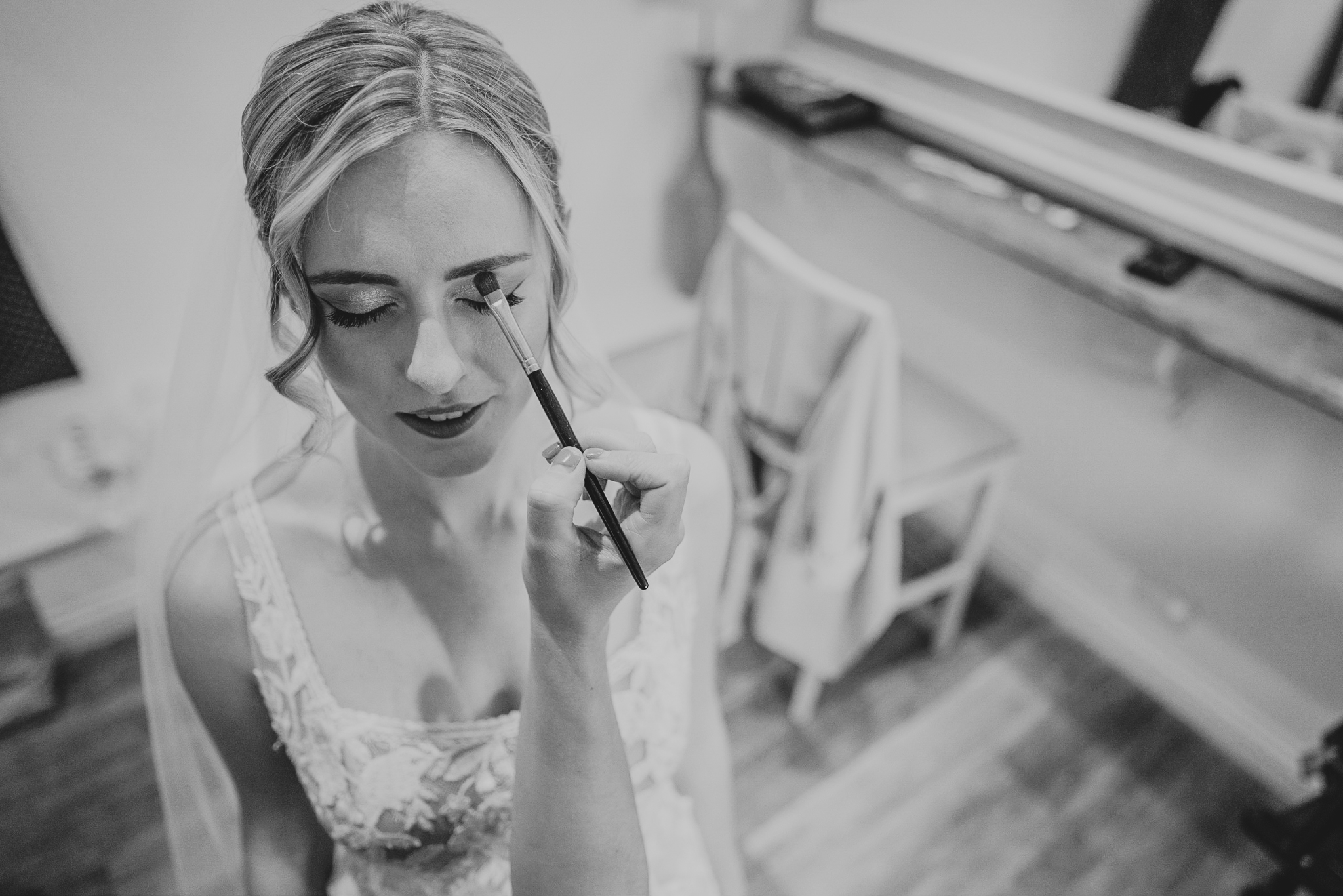 Shot from overhead, the bride receives make up from the MUA at Caswell House, Cotswolds.
