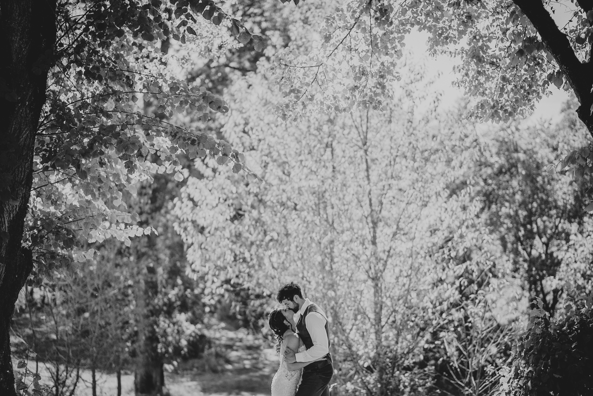 chateau-de-st-paul-wedding-photographer 9 – Alan Law Photography Amongst the trees, the couple kiss. At Château de St Paul.