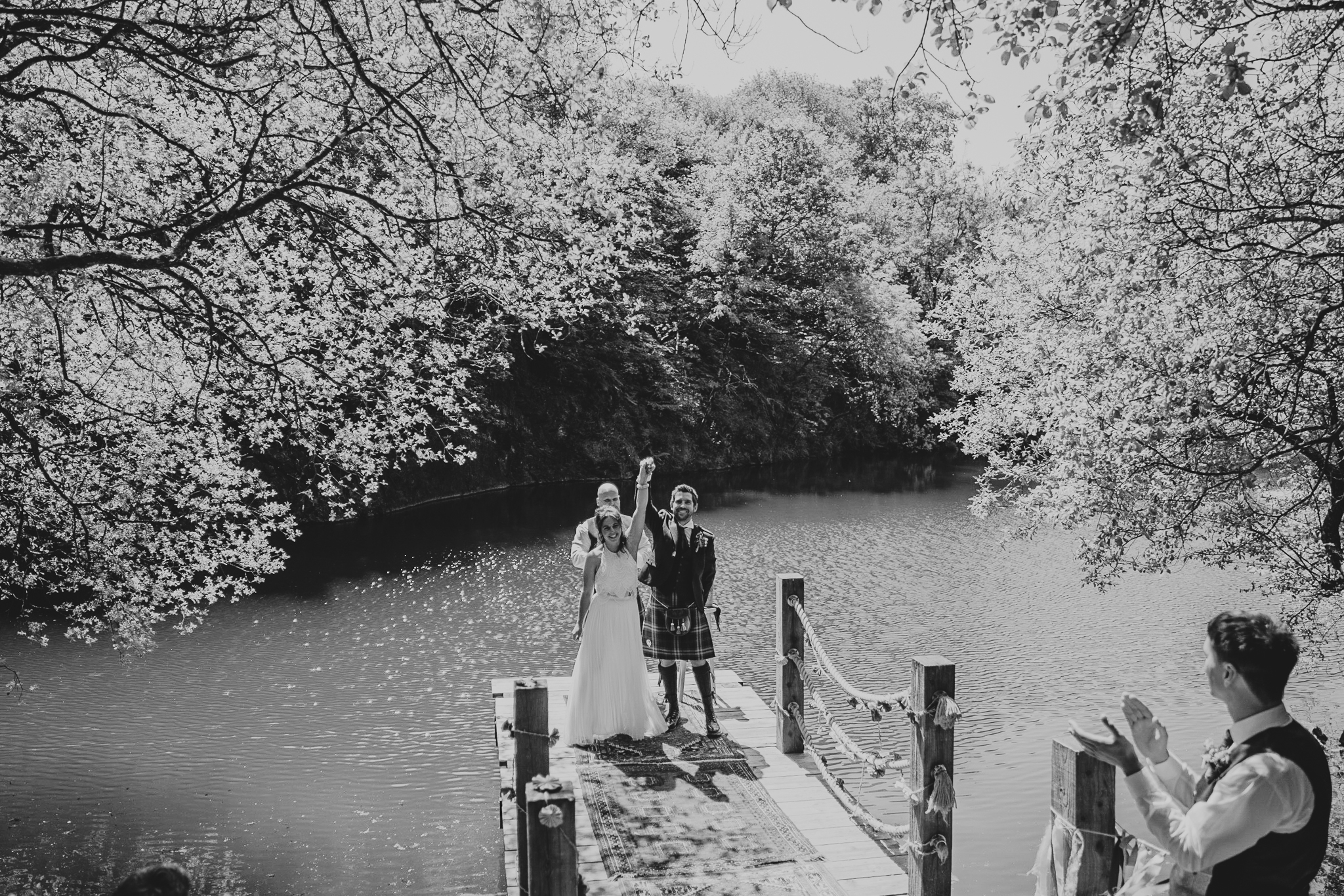 cornish-tipi-weddings-photographer 3 – Alan Law Photography The bride and groom lift their arms in the air, celebrating becoming husband and wife, during their outdoor ceremony at Cornish Tipi Weddings.
