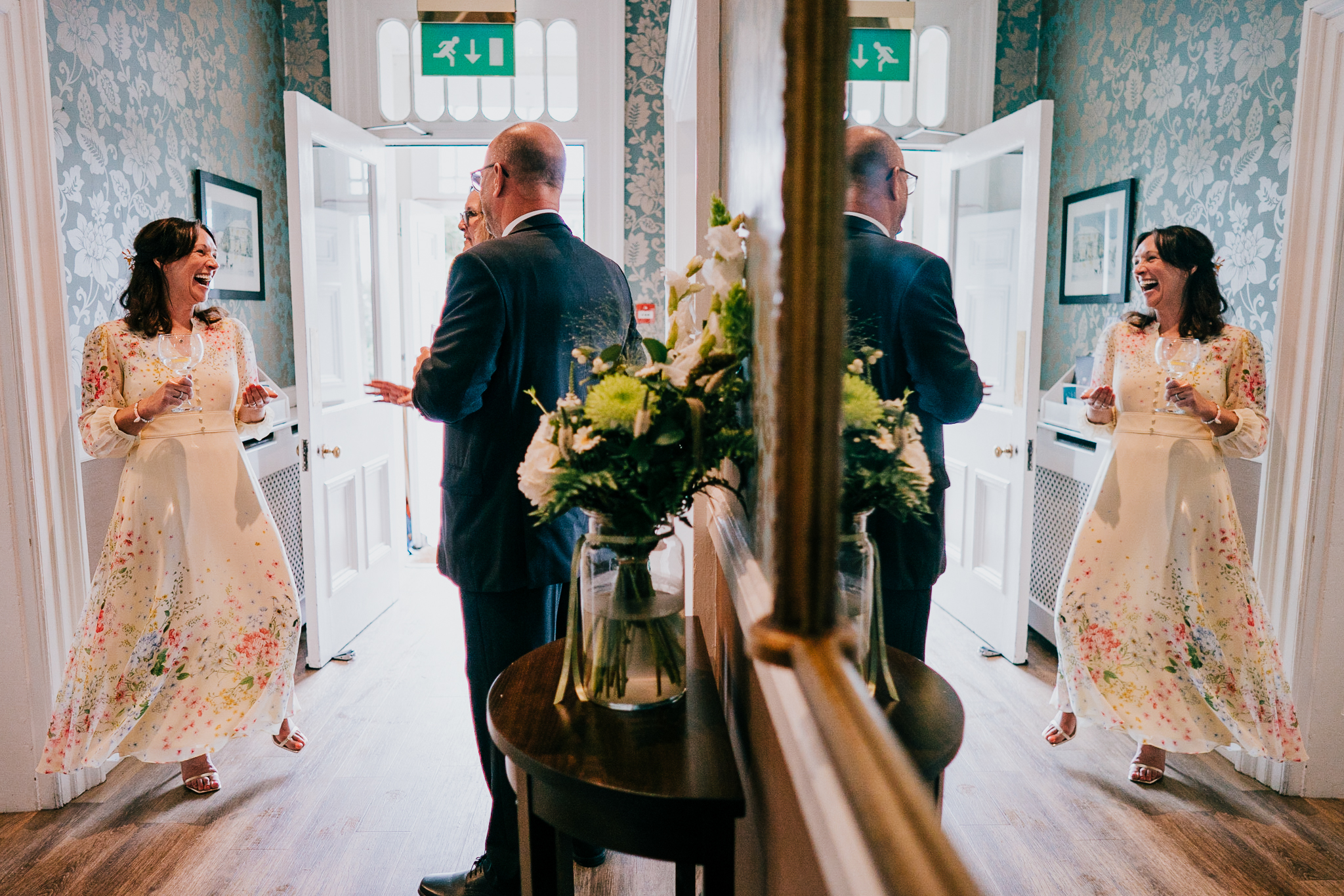 Bride laughing, reflected in a large mirror at The Horn of Plenty, Devon.