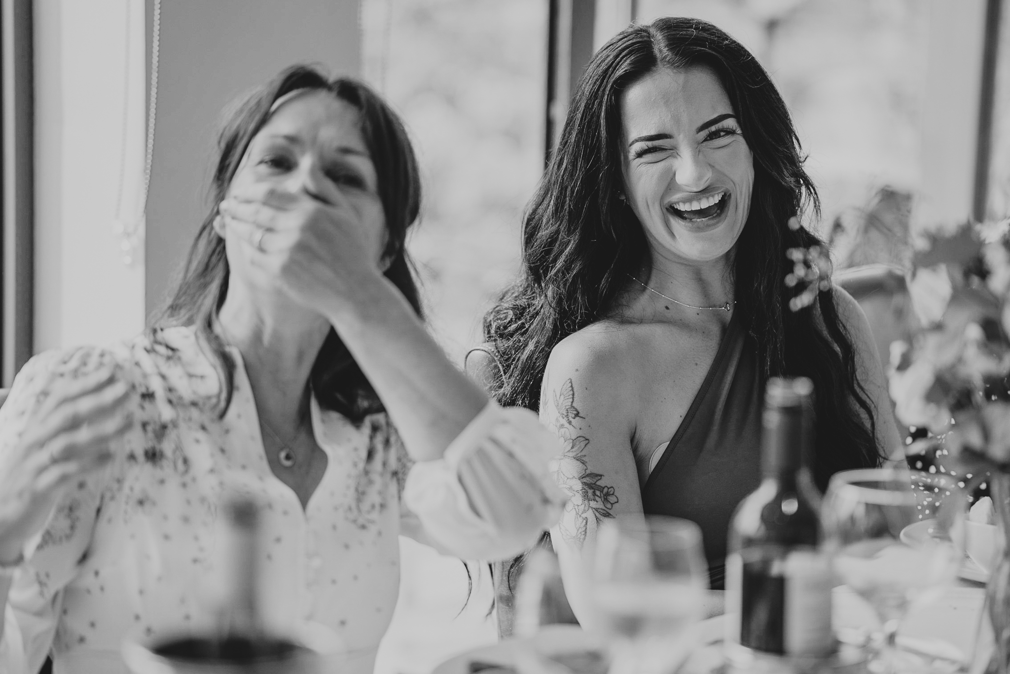 Bride and daughter laughing during the wedding breakfast at The Horn of Plenty, Devon.