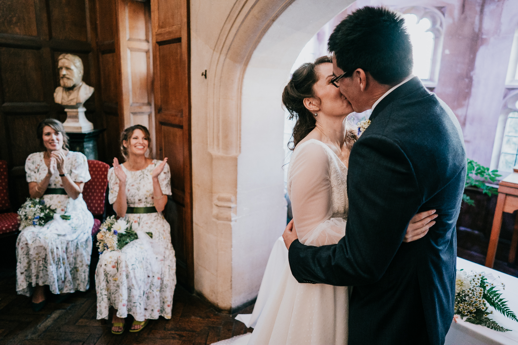 lynton-town-hall-wedding-photographer 5 – Alan Law Photography Penny and Greg's First Kiss at Lynton Town Hall, watched on by two bridesmaids.
