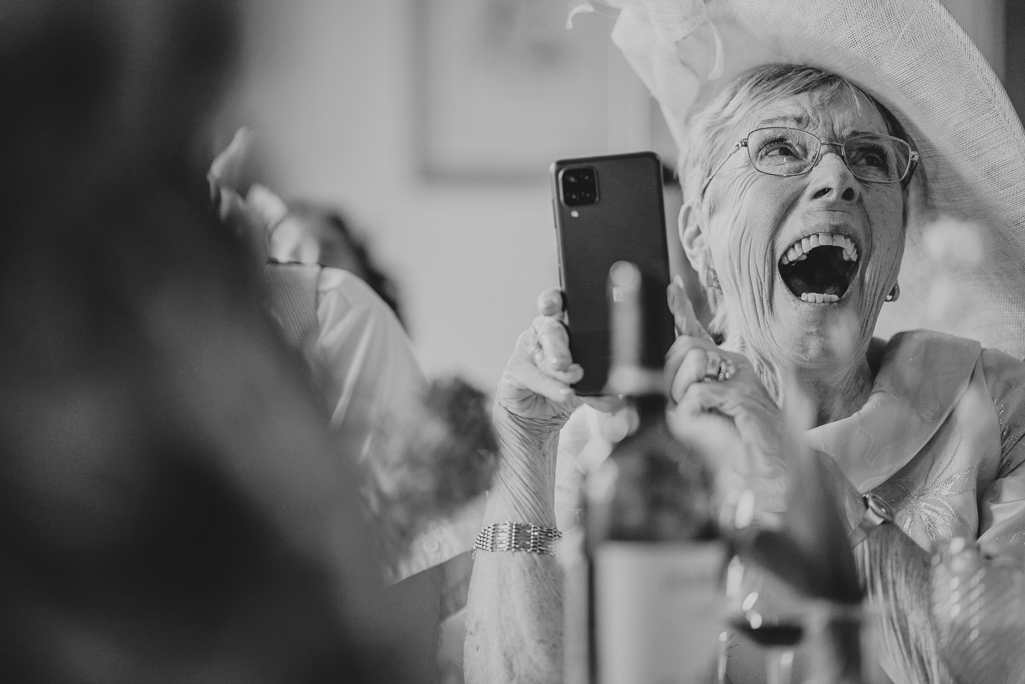 north-cadbury-court-wedding-photographer 2 – Alan Law Photography A wedding guest laughing loudly whilst filming the speeches at North Cadbury Court.