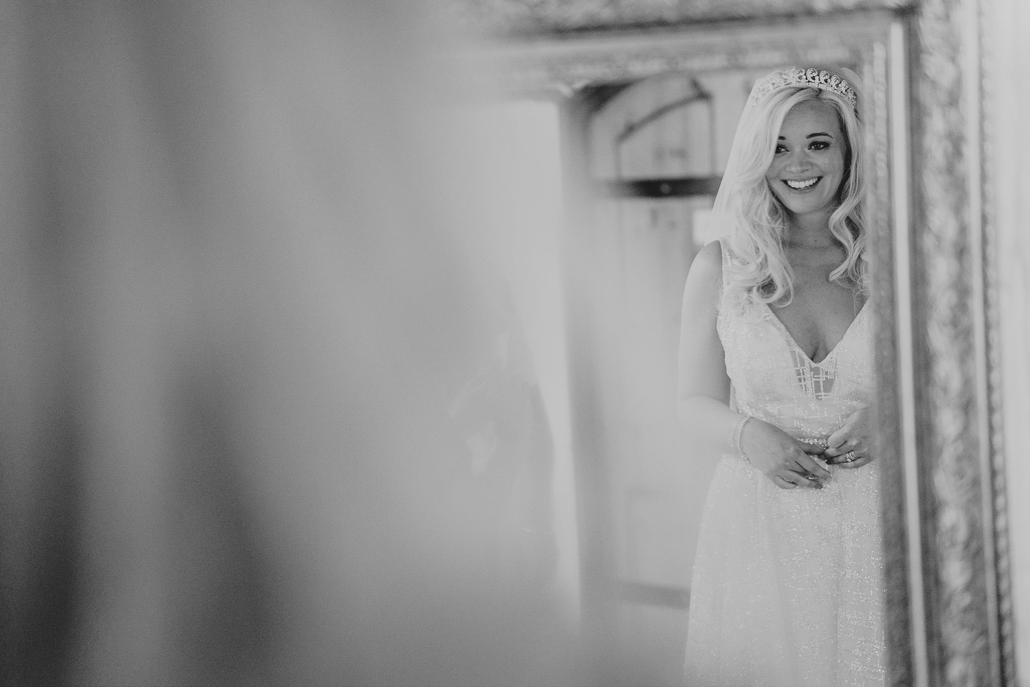 The bride looks in the mirror and sees herself in her wedding dress at Polhawn Fort.