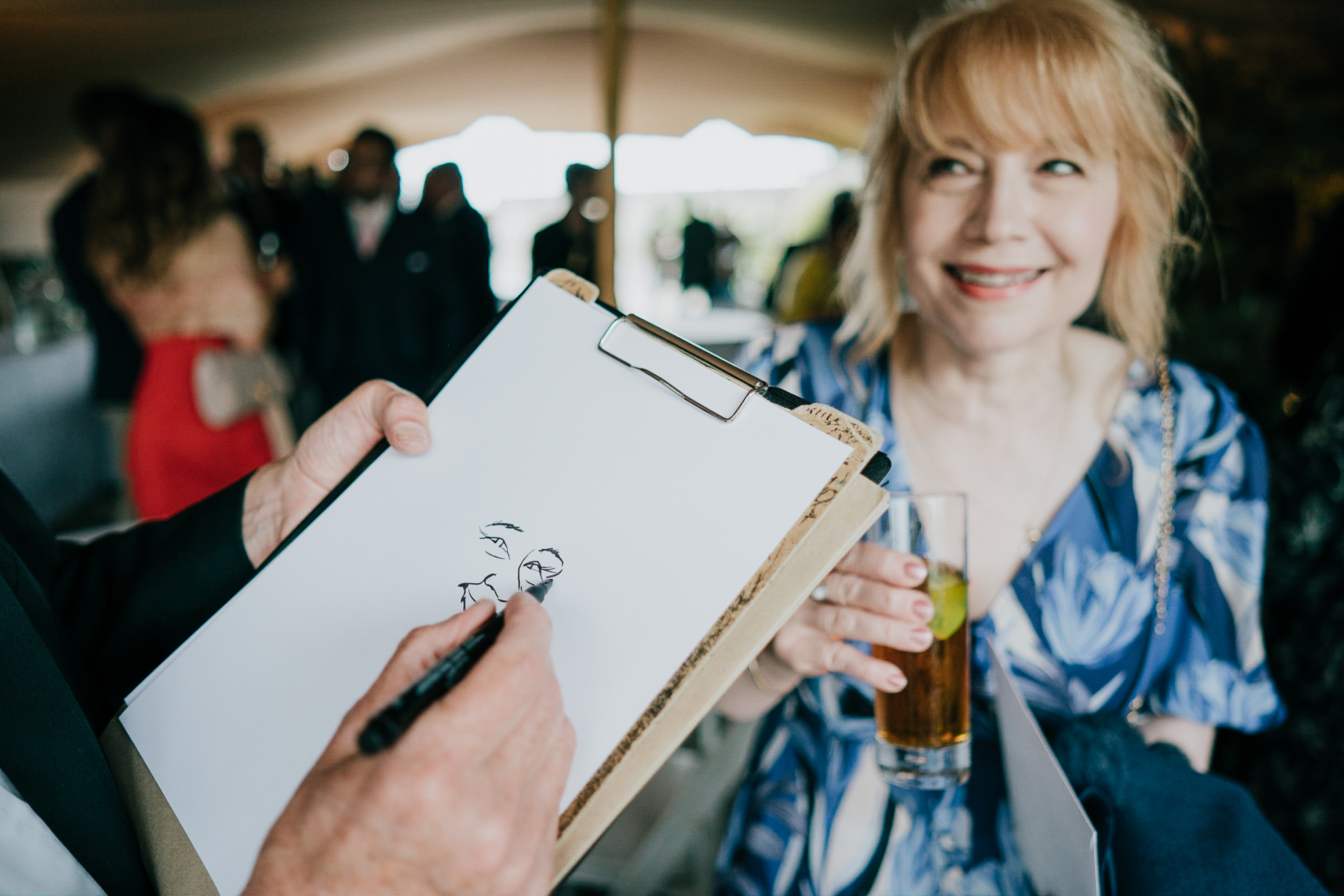 A caricaturist draws a wedding guest at Polhawn Fort