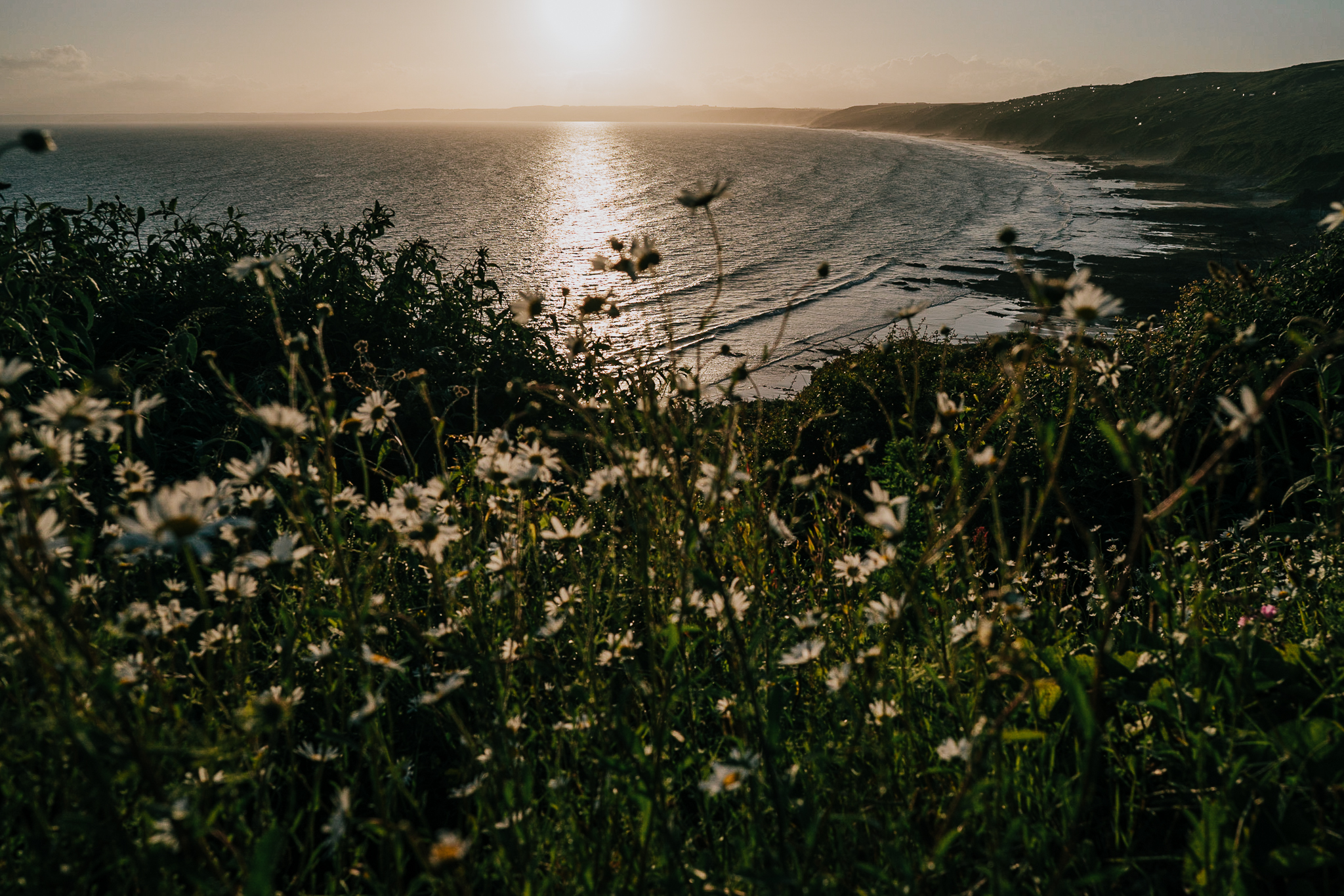 polhawn-fort-wedding-photography 10 – Alan Law Photography The sea and Cornwall coastline, with flowers in the foreground, taking as the sun sets at Polhawn Fort.