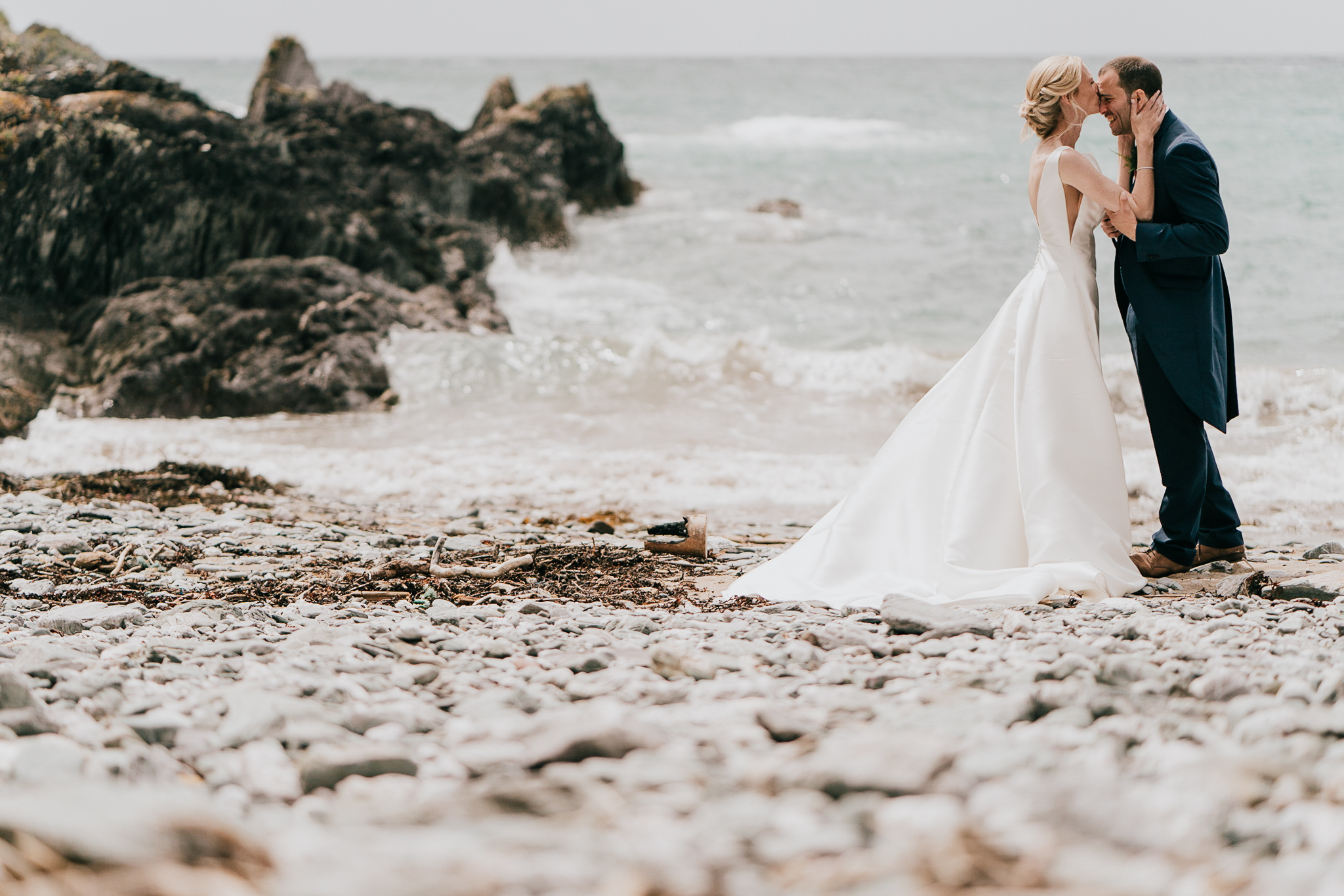 polhawn-fort-wedding-photography 7 – Alan Law Photography Melanie and Jack share a moment on the beach at their Polhawn Fort wedding, with Mel kissing her new husband on the forehead.