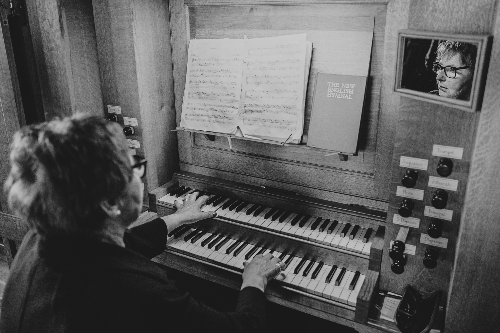 port-isaac-wedding-photographer 7 – Alan Law Photography A shot from behind the organist at St Endellion Church, with her face reflected in a mirror.