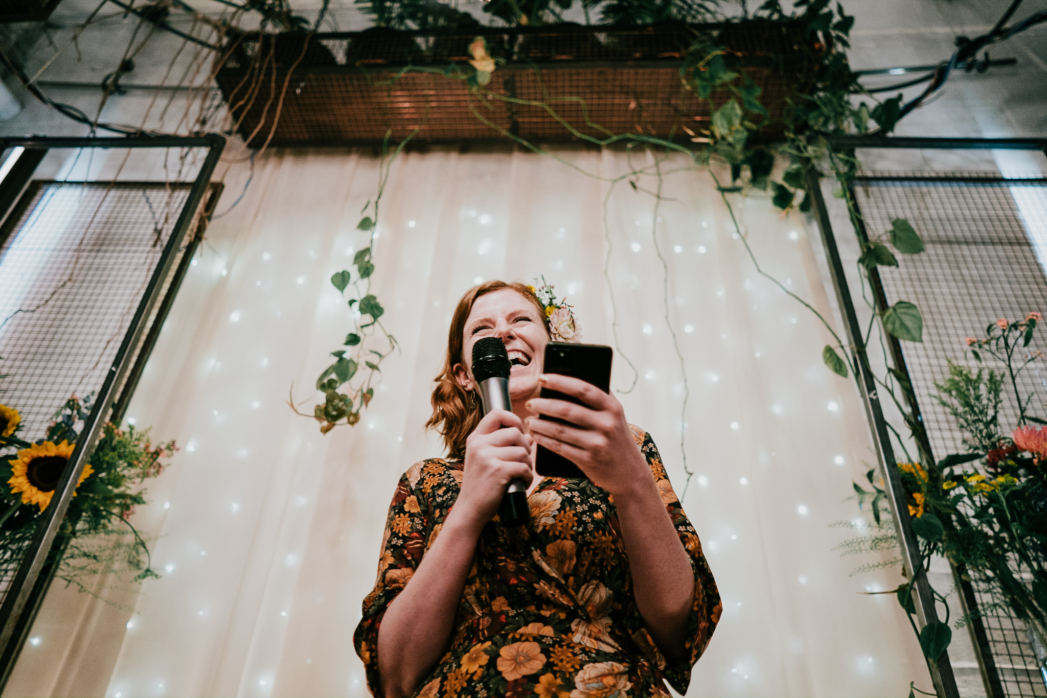 A bridesmaid does a speech at The Hackney, shot close and from below; she is laughing.